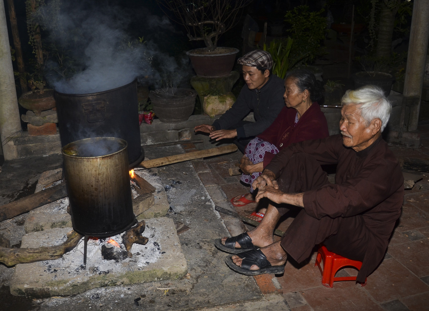 Đ&ecirc;m ngồi canh lửa nấu b&aacute;nh tết - Ảnh: H.C.D