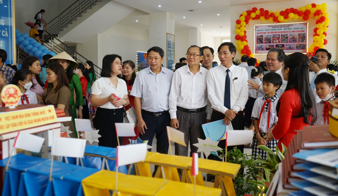 Đại biểu v&agrave; c&aacute;c em học sinh tham quan triển l&atilde;m trưng b&agrave;y tư liệu, xếp m&ocirc; h&igrave;nh s&aacute;ch nghệ thuật