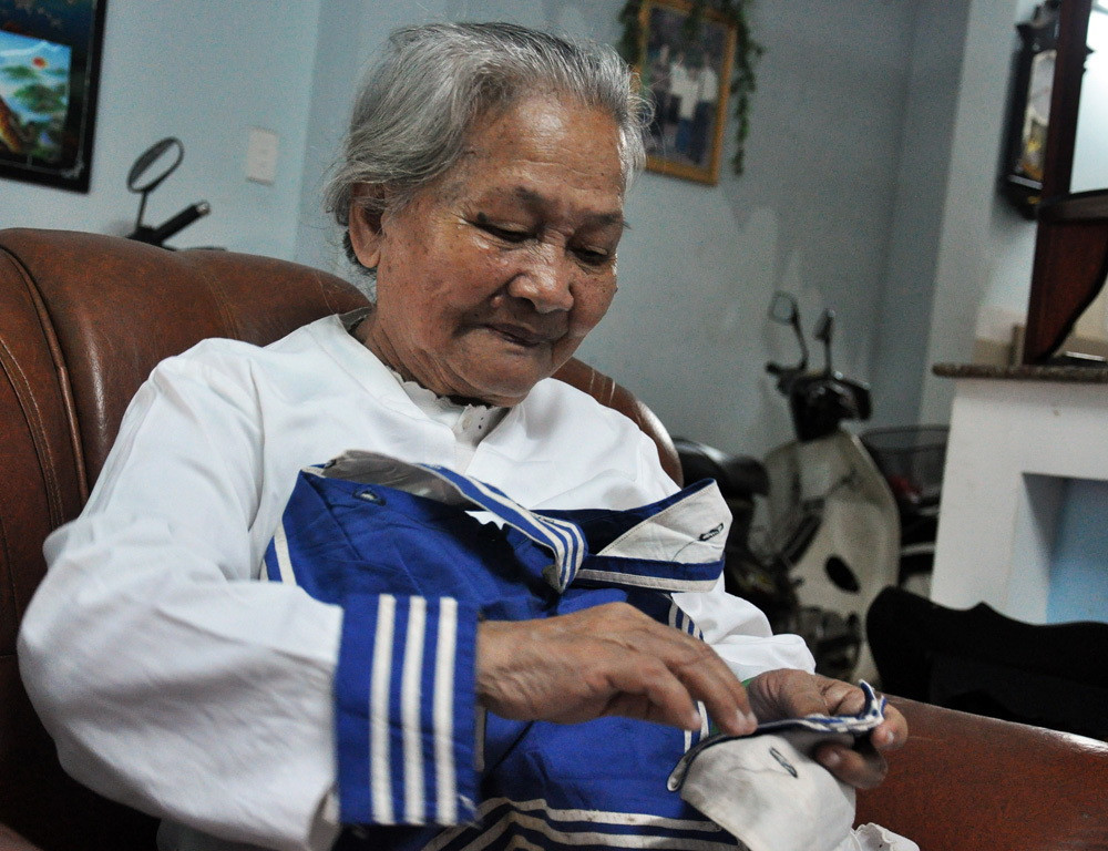 Mẹ L&ecirc; Thị Muộn ở Đ&agrave; Nẵng v&agrave; tấm &aacute;o con trai, liệt sĩ Gạc Ma &ndash; anh Phan Văn Sự  - Ảnh: L.Đ.D