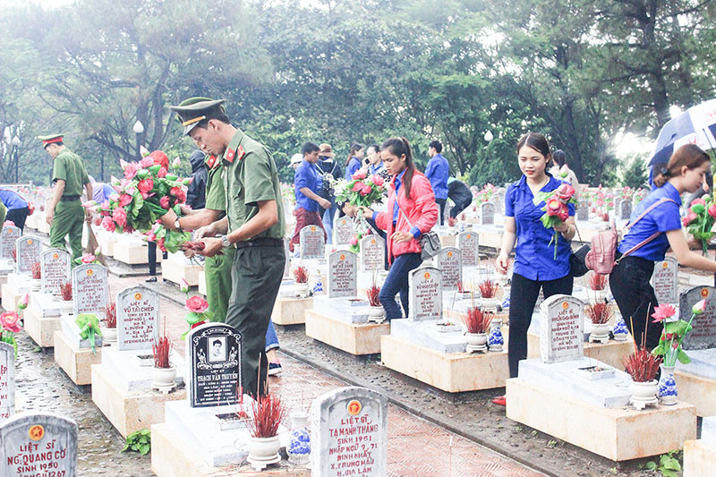 Đo&agrave;n vi&ecirc;n thanh ni&ecirc;n chăm s&oacute;c c&aacute;c phần mộ liệt sĩ tại Nghĩa trang liệt sĩ quốc gia Trường Sơn - Ảnh: A.Q